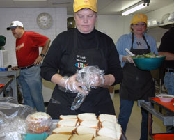 Cathedral Kitchen and Food Pantry volunteers, from left, Immaculate Heart of Mary parishioner Rick Sparks of Indianapolis and Our Lady of Mount Carmel parishioners Sally Dennis and Deanna Reckelhoff of Carmel, Ind., in the Lafayette Diocese, prepare food for homeless and low-income people on Nov. 16, 2005, at the ministry’s location at 14th and Pennsylvania streets in Indianapolis. (File photo by Mary Ann Wyand) 