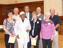 Among those recognized for years of service during the Catholic Charities’ volunteer dinner on April 13 at the Archbishop Edward T. O’Meara Catholic Center in Indianapolis are, front row, Karen Boyer, left, (10 years); Florine Harrington (10 years); Linda Hegeman (five years); and Fran Doyle (10 years). Second row: Richard Moore (10 years); David Bethuram, agency director of Catholic Charities Indianapolis; Jim Schutter (five years); and Ed Doyle (10 years). Not pictured is Jane Keller, who was recognized for five years of volunteer service. (Photo by Mike Krokos)