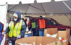 Volunteers place food in the trunk of a car on March 28 as part of the temporary drive-through process the Indianapolis Society of St. Vincent de Paul’s leadership devised for its Food Pantry to adapt to guidelines during the COVID-19 outbreak. (Submitted photo by SunShine Rucker)