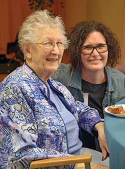 St. Augustine Home Guild member Kathy Smith, right, smiles with home resident Anne Wickens during a High Tea event the guild hosted for residents of the St. Augustine Home in Indianapolis on April 19. (Photo by Natalie Hoefer)