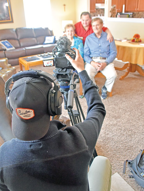 Casey Shaffer of Colorado-based Lux Lab Production House snaps a shot of Mark Hublar, middle, with his parents Linda and Al Hublar in Mark’s New Albany apartment on May 29 for a short video featuring Mark to be shown at an evening revival session in Lucas Oil Stadium during the National Eucharistic Revival in Indianapolis on July 17-21. (Photo by Natalie Hoefer)